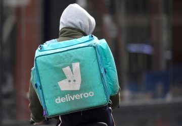 A Deliveroo delivery rider cycles in London, Britain
