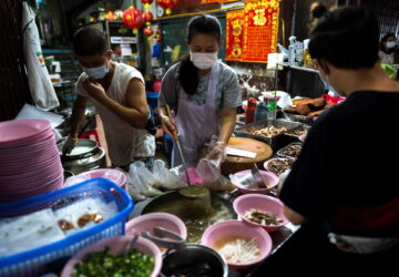 Adulwitch Tangsupmanee, 42, and Jirintat, son and daughter of Chanchai Tangsupmanee, who died at age 73 of the coronavirus disease (COVID-19) in July, during Thailand's worst wave of infections prepare meals at their late father's food stall in Bangkok's Chinatown