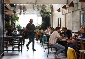 Cafe manager Rhyss Kearns serves customers at Bay Ten Espresso, a cafe that has struggled with filling staff job openings in recent months due to a worker shortage according to its owner, in Sydney, Australia