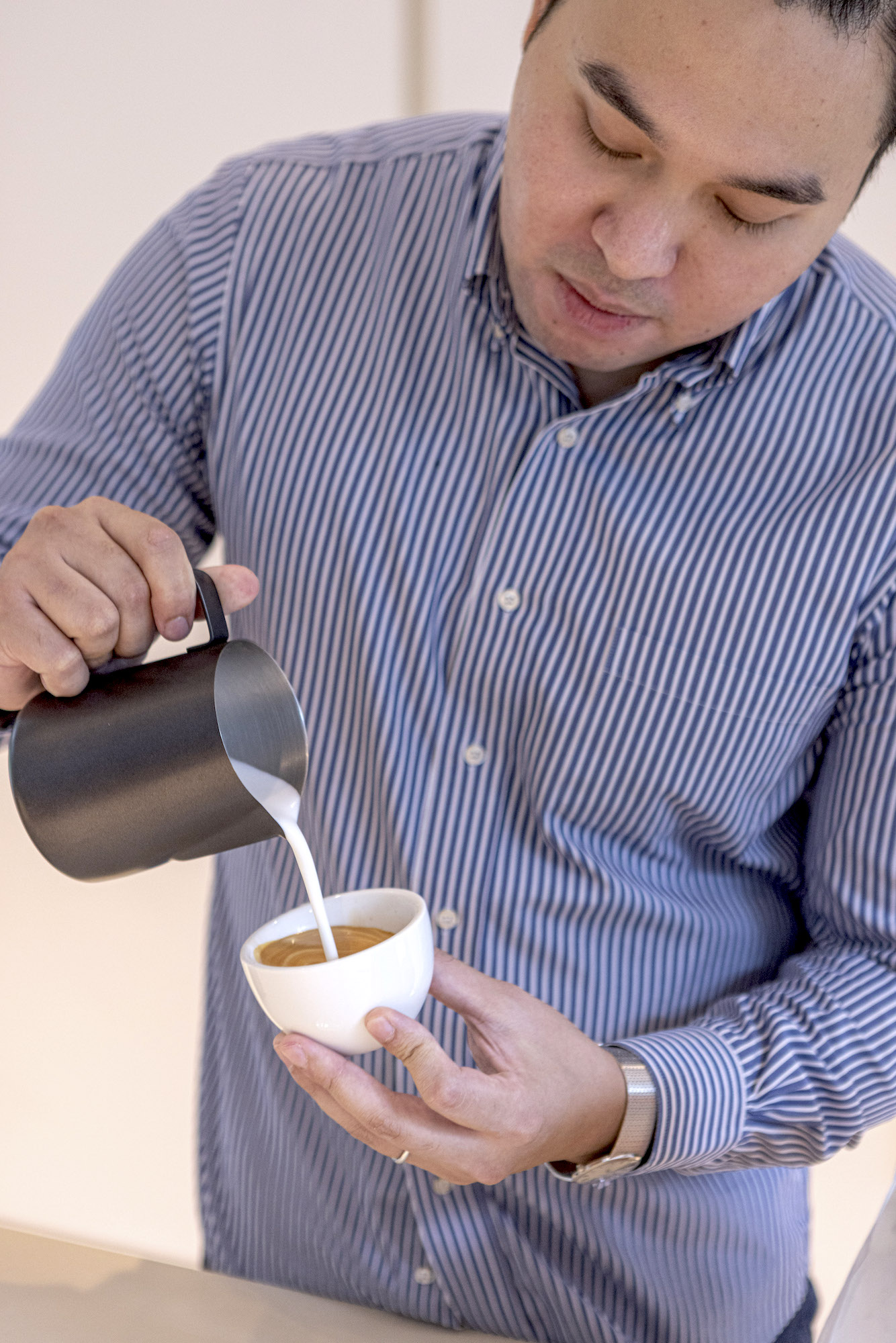 Gio Visitacion making a flat white with the Letty Bermudez Gesha variety with notes of peach, strawberry, mango, and honey